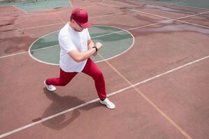 Athletic bearded man warms up before workout at the stadium photo