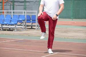 Athletic bearded man warms up before workout at the stadium photo