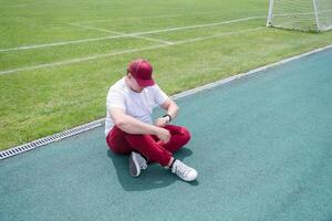 Athletic bearded man resting sitting at the stadium photo