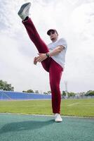 Athletic bearded man warms up before workout at the stadium photo