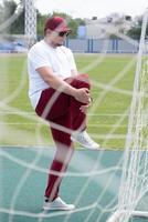 Athletic bearded man warms up before workout at the stadium photo