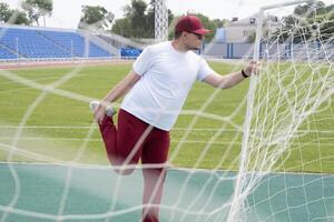 Athletic bearded man warms up before workout at the stadium photo