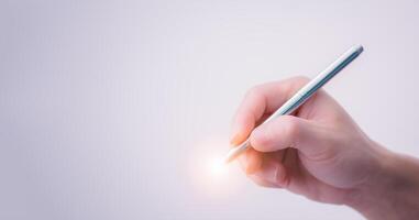 Close-up of a man's right hand holding a pen preparing to start writing or signing on the white background, the concept of signing a document or accepting an agreement with digital technology. photo