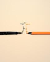 Work Life Balance Copceptual Photo, top view of a Vulture Business Pen and an Orange Colored Pencil, Connected the lines by Drawing a Human Body Shape photo