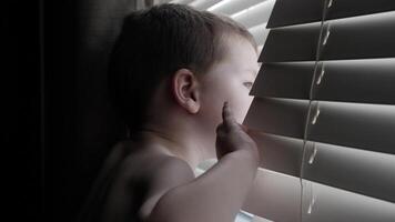 Young Little Boy Looking Out Window At Home video
