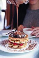 Chocolate Drizzled Banana and Cookie Pancake Stack photo