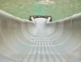 Gray colored plastic slide playground park toy isolated on horizontal ratio first person point of view background. photo