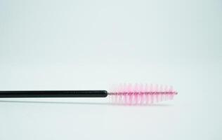 Mascara eyelash brush with black and pink color beauty tool object isolated on horizontal ratio white copy spaced background. photo