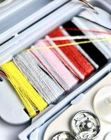 Close up sewing or tailoring kit colorful threads and buttons object equipment tools isolated on vertical ratio background photography. photo