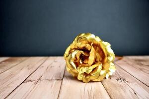 Gold rose flower petal from front view. Object photography isolated on horizontal ratio wooden surface background. photo