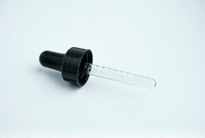One single pipette lid pump with rubber and clear glass material. Small object photography isolated on horizontal ratio white background. photo