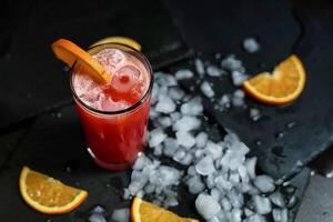 Refreshing Red Drink With Orange Garnish and Ice photo