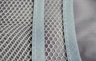Inside part of travel bag pouch organizer compartment for storing make up, medicine, and other small objects. Gray net bag isolated on horizontal ratio background. photo