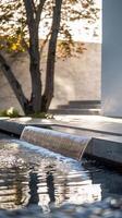 A minimalist garden with a sleek water feature, such as a smooth waterfall or reflective pond, against a clean white background photo