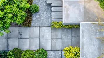 A minimalist garden with a combination of concrete pathways and gravel beds, with a few strategically placed plants photo