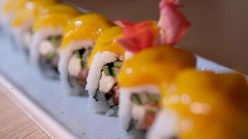 sushi rullar är roterad i paket efter leverans. philadelphia rulla i sushi uppsättning stänga upp. traditionell japansk mat. japansk kök med hav mat. tar ett sushi rulla från uppsättning använder sig av ätpinnar. video