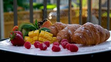 Croissants fruit Breakfast from above. 4k camera rotation with two croissants and orange juice in glasses on a wooden table. Breakfast . video