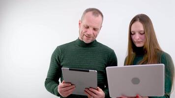 Man and woman working on laptop computers teach intern training new worker consult customer explain online business services computer corporate software look at laptop screen at office meeting video