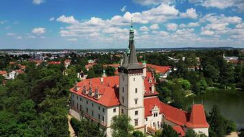 Aerial backwards view of chateau Pruhonice tower and pond in Czechia in June 2024 video
