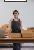 Portrait of Asian young woman SME working with a box at home the workplace.start-up small business owner, small business entrepreneur SME or freelance business online and delivery concept. photo