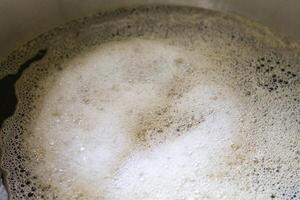 Boil malt grain in a pot in a home brewing process. Fermentation of grain for craft beer. Concept of home beer making photo