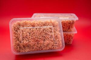 Boxes of sweet and sour crispy noodles or Mee krob in the Thai language placed on a red background. photo