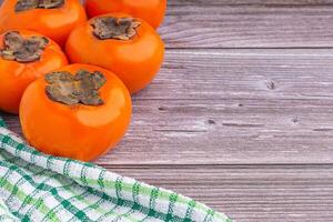 Top view of persimmons with cloth on a gray stone background with copy space for text. Concept of health fruit photo
