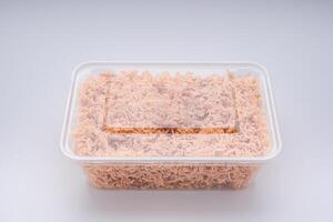 Package for sale of sweet and sour crispy noodles or Mee krob in the Thai language placed on a white background. Side view with copy space for text photo