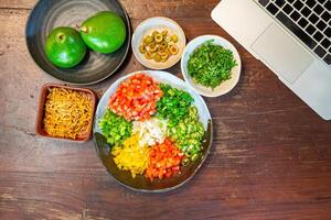 Top view of preparing cooking for loaded minced pork nachos with guacamole and salsa dips photo