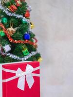 Close-up of Christmas tree background and Christmas decorations with a gift box. The theme of Happy New Year and Xmas. Space for text photo