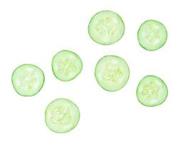 Top view set of green cucumber slices or pieces in circle shape scattering isolated on white background with clipping path photo
