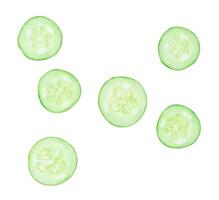 Top view set of green cucumber slices or pieces in circle shape scattering isolated on white background with clipping path photo
