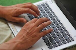Close up image of Man hands typing on laptop computer keyboard, working, business and technology, internet network communication concept photo