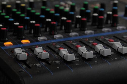 Close-Up View of an Audio Mixer with Numerous Knobs and Controls photo