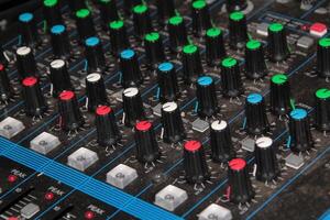 Close-Up View of an Audio Mixer with Numerous Knobs and Controls photo