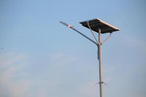 a solar-powered street light with a clear blue sky background. photo