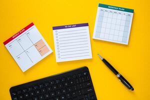 Manager is planning a busy week using a calendar, a monthly planner and a to do list photo