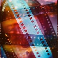 Detailed view of a film strip, perfect for illustrating photography concepts. Create a captivating 3D scene featuring a blank cinema filmstrip from a unique perspective photo