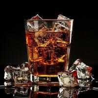 Glass of refreshing cola with ice cubes on a black background. Cool summer soda mockup. photo