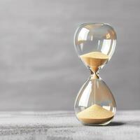 Hourglass. Sand passing in hourglass, countdown running time, deadline on grey background copy space. Falling sand showing the passing time of hourglass close-up and isolated concept for business photo