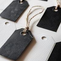 Black and white tags with strings on a gray background, blank tags concept, mock-up, copy space. Label tag mockup. Label Tag mockup template. Cloth label tag blank mockup. Price Label tag mockup. photo