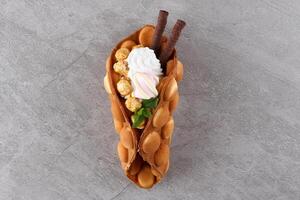 Hong kong or bubble waffle with ice cream and fruits isolated on white background photo