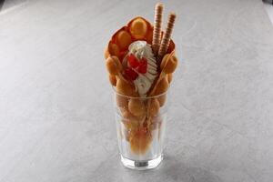 Hong kong or bubble waffle with ice cream and fruits isolated on white background photo