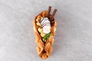 Hong kong or bubble waffle with ice cream and fruits isolated on white background photo