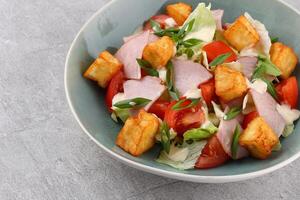 Salad with spinach, cheese, ham, grapefruit and balsamic sauce on a wooden rural background. Top view. Close-up. photo