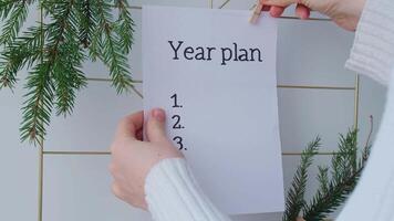 Vision board with YEAR PLAN new year resolutions aims goals on paper note. Preparation for New Year. Concept of planning and setting goals for personal development video