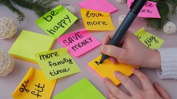 Woman writing promises goals and aims. Preparation for new year new life new me. Visualizing wish list for 2025. Dreams plan action resolutions for coming year. Inspirational self improvement concept video