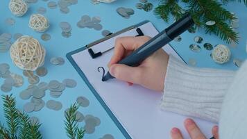 2025 GOALS New year's resolutions on paper note with Christmas decor. Making promises for new year, setting goals. Creating dream vision board motivation video