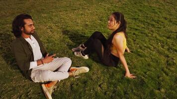 Man and woman sitting on grass and talk video