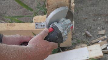 A man is using a power tool to cut wood. Concept of productivity and hard work. Slow motion video